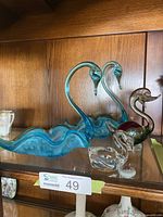 Shelf with two large blue swan bowls, multicolor swan, small clear swan