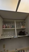 Cupboard showing entire lot of glasses, tumblers and stacked plates