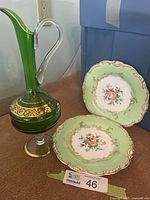 Lot overview showing green glass decanter and two green-rim floral plates