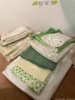Stacked green and white linens showing various patterns including shamrocks, damask and polka dots