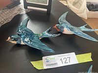 Two large Beswick ceramic swallows on black surface