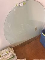 Full view of round glass topper leaning against wall