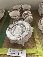 Four mugs and stacked plates showing full set