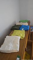 Row of six folded long sleeve tops in various colors
