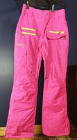 Front view of hot pink Firefly ski pants with yellow zippers and cargo pocket