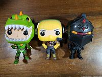 Front view of three Funko Pop Fortnite figures: Rex, Raptor, Black Knight
