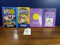 All four paperback books standing upright showing front covers