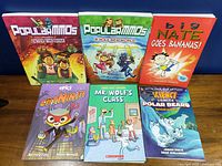 Front covers of all six graphic novels laid out on table