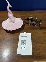 Overall view of both ceramic figurines: pink mermaid shell dish and green fish