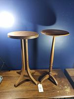 two wooden plant stands side by side against blue wall