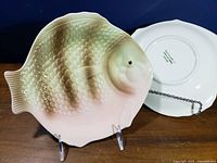 Front view of fish-shaped plate and backside of another showing mark