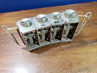 Top-down view of 4-bay coin chute rack showing coin lids and denomination labels