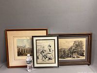 Three framed art prints side by side with water bottle for scale