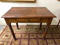 Full view of antique wooden table with drawer and legs