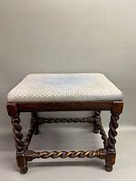 Front view of stool showing upholstery and barley twist legs