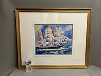 Framed painting with water bottle for scale