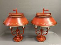 Front view of both matching painted tin lamps with shades attached