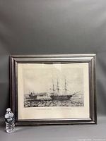 Full view of framed USS Constitution print beside water bottle for scale