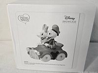 Box showing monochrome image of figurine and branding