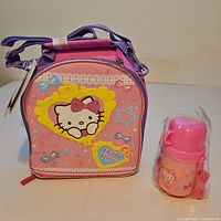 Front view of Hello Kitty lunch bag beside thermos