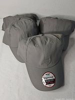 Four grey Imperial True Fit hats