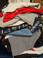 Stack of folded men’s shirts and tops showing variety of colors and patterns