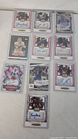 Group shot of all 10 autographed football cards in sleeves