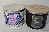 Both candles side by side showing labels and lids