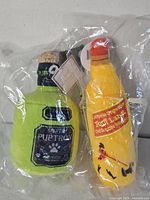 Both plush liquor bottle dog toys sealed in plastic wrappers