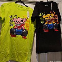 Both shirts hanging to show colors and graphics