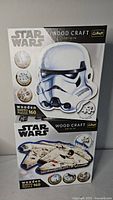 Front view of both boxed Star Wars wooden puzzles showing Stormtrooper helmet and Millennium Falcon images