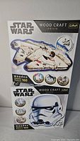 Front view of both sealed Star Wars Trefl Wood Craft Origin puzzle boxes showing Millennium Falcon and Stormtrooper designs