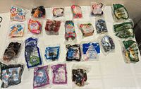 Overhead view of all 23 sealed Happy Meal toys laid out on table