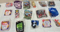 All 16 sealed Happy Meal toys laid out in four-by-four grid