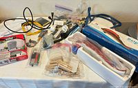 Entire lot on table showing grill cover box, massager, cables, tools, clothespins