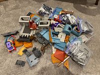 pile of assorted castle building toy parts spread on carpet