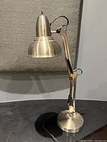 Full view of lamp showing base, adjustable arm and shade
