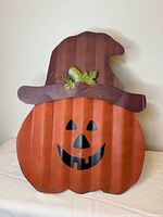 Front view of metal jack-o-lantern with hat