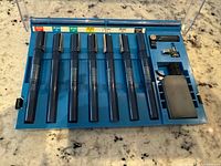 Open case showing seven pens, ink bottle and wrench