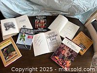 Overview of 10 books, several open showing signatures and titles