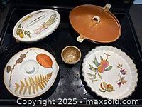 Five bakeware pieces laid out: three Evesham dishes, brown Canadian casserole with lid, pottery egg separator