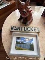 All three items together: cement fox statue, Nantucket sign, framed landscape painting