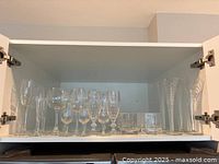 Cabinet shelf showing complete assortment of glassware