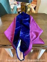 UWO full hood folded on table showing magenta exterior and blue velvet interior