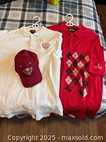 White polo, red argyle polo, maroon hat