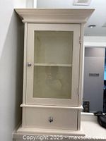 Front view of white wood medicine cabinet, door closed