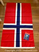 Full view of Norwegian flag laid flat with book placed on it