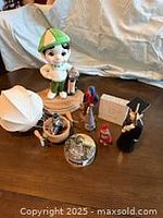 Group shot of watch tin, balloon ornament, and assorted ceramic figurines