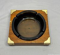 Top view of square walnut ashtray showing brass corners and glass insert
