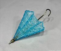 Full view of blue glass umbrella vase showing pattern, handle and tip